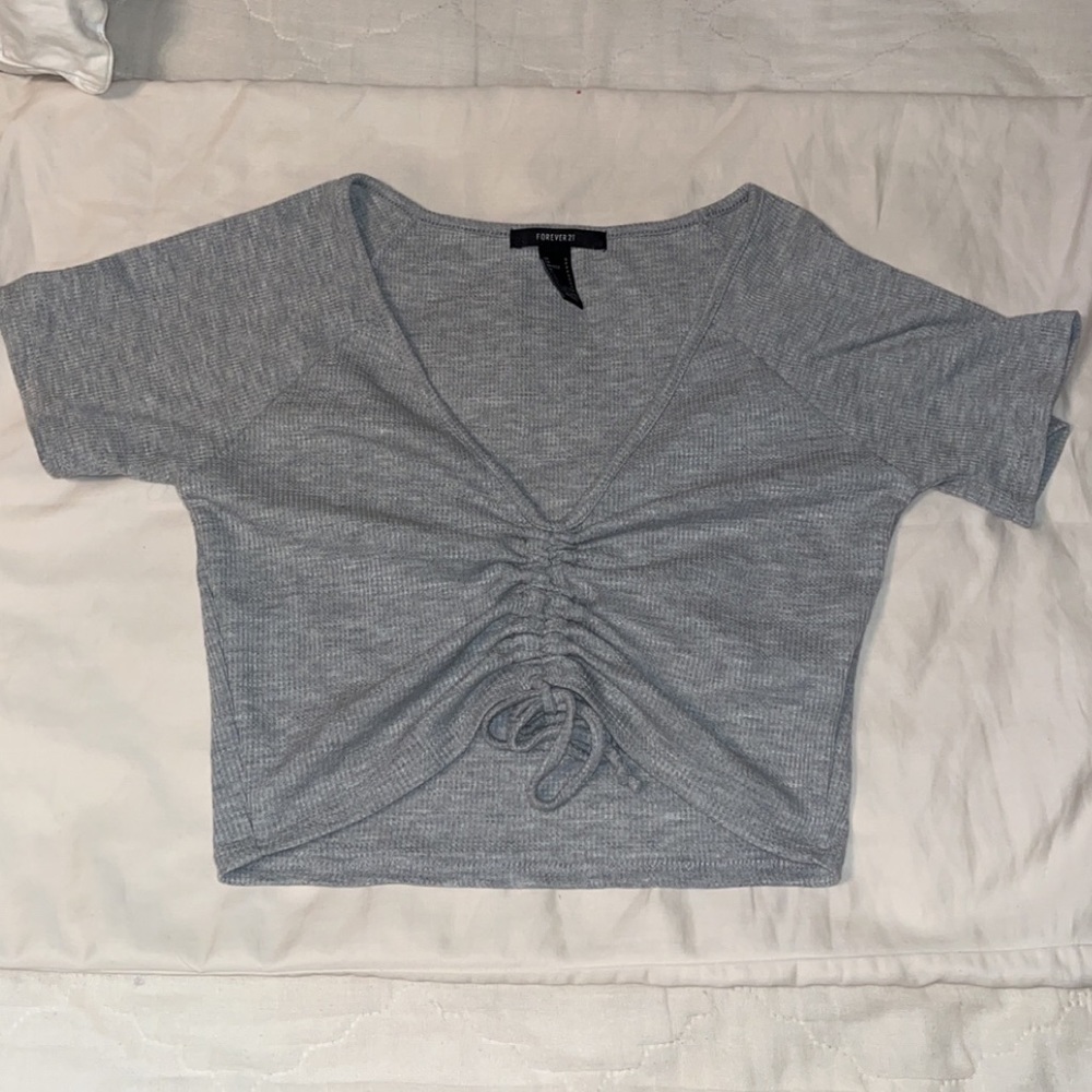 Grey crop top. Length adjustable with the tie on front. Soft and form fitting